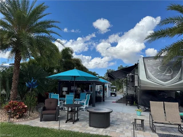 View of patio with an outdoor fire pit and a gazebo