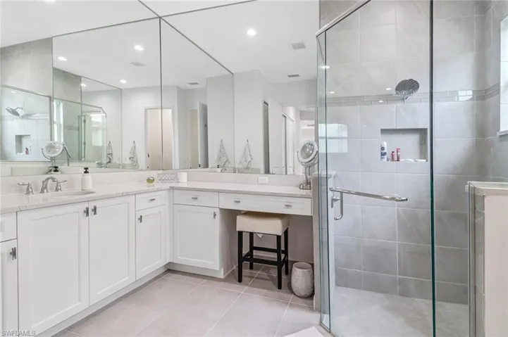 Full bathroom with a shower stall, vanity, light tile patterned floors, and recessed lighting