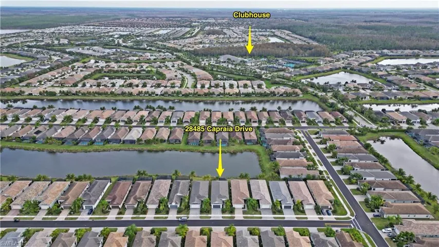 Aerial view of property and surrounding area with nearby suburban area and a large body of water