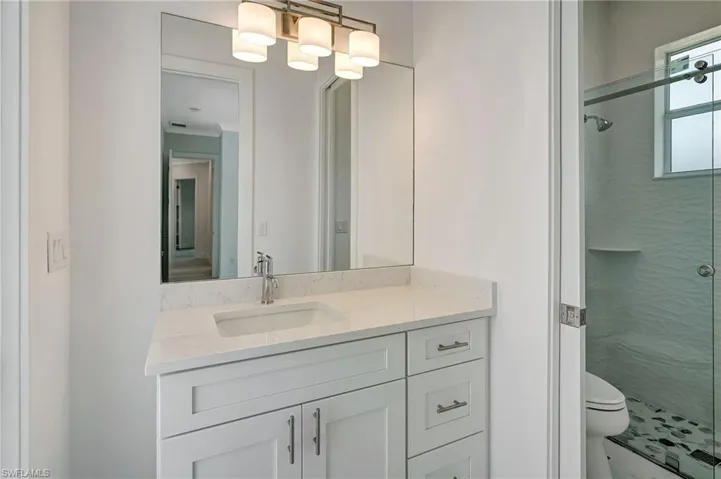 Bathroom with a stall shower, toilet, and vanity