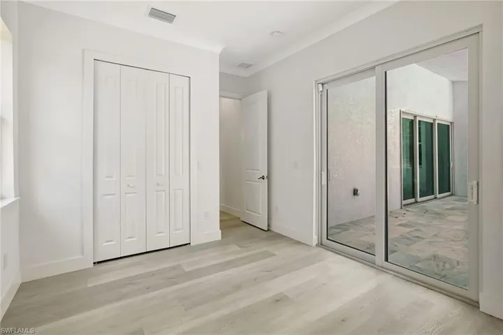 Unfurnished bedroom with light wood finished floors, baseboards, and ornamental molding