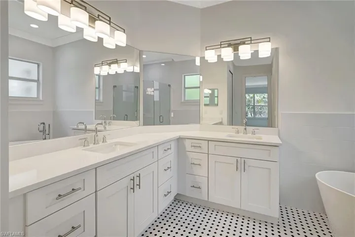 Full bath featuring a stall shower, healthy amount of natural light, vanity, a soaking tub, and tile walls