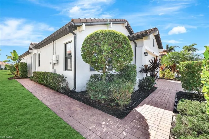 View of side of property with stucco siding and a yard