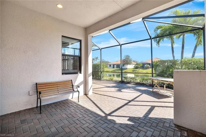 View of patio with a sunroom, a lanai, a water view, and a residential view