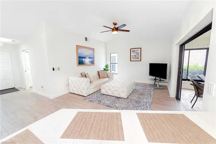 Living room with plenty of natural light, a ceiling fan, and light wood finished floors