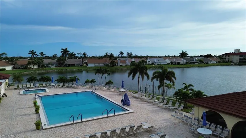Community pool featuring a water view, a community hot tub, a patio area, and a residential view