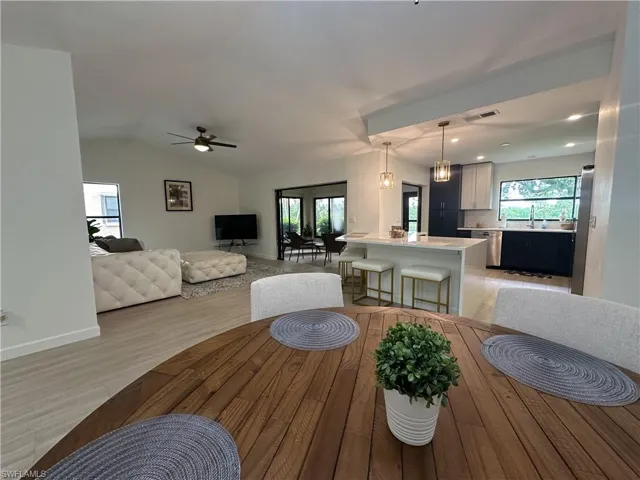 Dining room with recessed lighting, light wood-type flooring, a ceiling fan, and vaulted ceiling