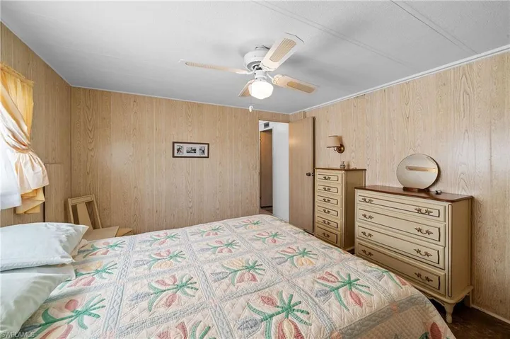 Bedroom with wood walls and a ceiling fan