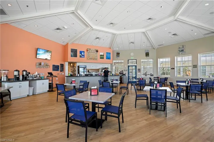 Dining space featuring a high ceiling, light wood-style floors, and beam ceiling