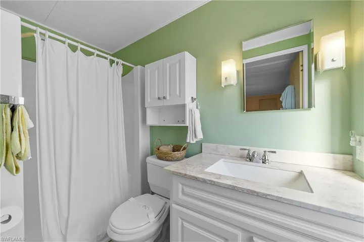 Bathroom featuring curtained shower and vanity