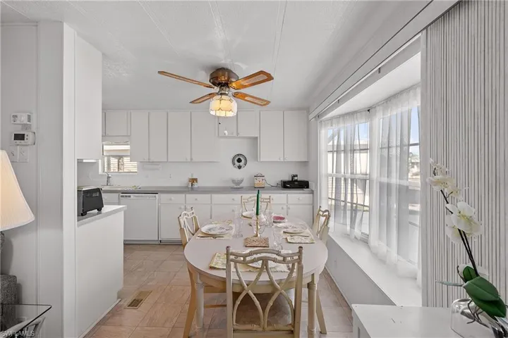 Kitchen featuring white cabinetry, white dishwasher, a ceiling fan, a textured ceiling, and light countertops
