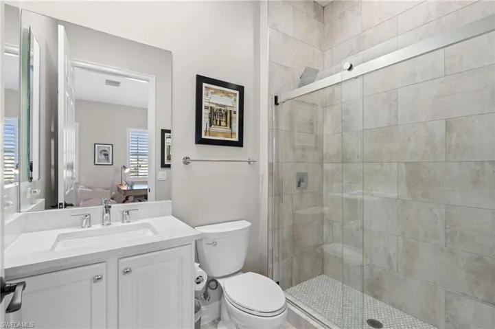 Ensuite bathroom featuring visible vents, toilet, ensuite bathroom, and a stall shower