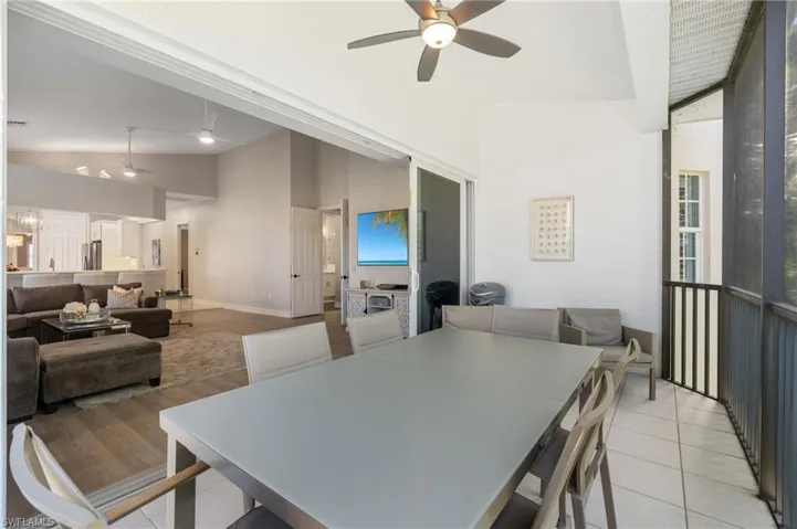 Dining area with high vaulted ceiling, light tile patterned floors, baseboards, and a ceiling fan