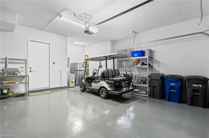 Garage with a garage door opener and freestanding refrigerator