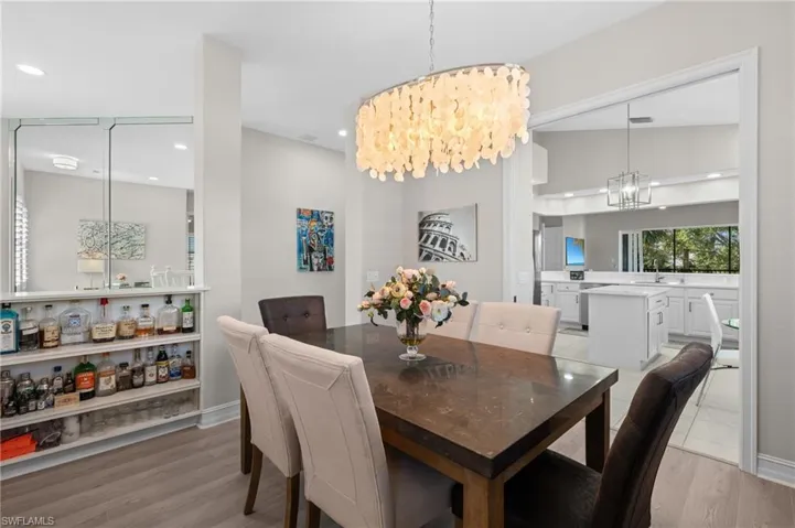 Dining space featuring light wood finished floors, a notable chandelier, and recessed lighting