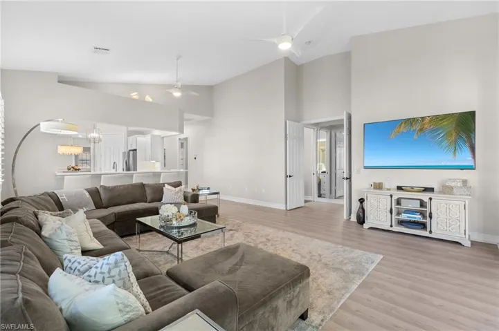 Living area with visible vents, baseboards, a ceiling fan, and light wood finished floors