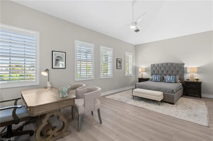 Bedroom featuring light wood finished floors, baseboards, a ceiling fan, and visible vents