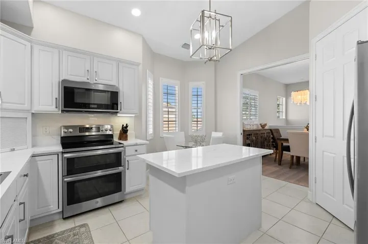 Kitchen featuring light tile patterned floors, an inviting chandelier, and stainless steel appliances