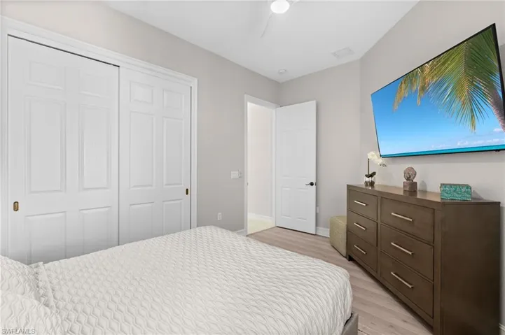Bedroom featuring a closet, baseboards, light wood-style floors, visible vents, and ceiling fan
