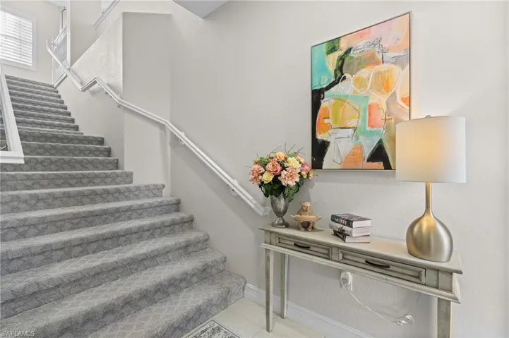 Stairs with baseboards and tile patterned flooring