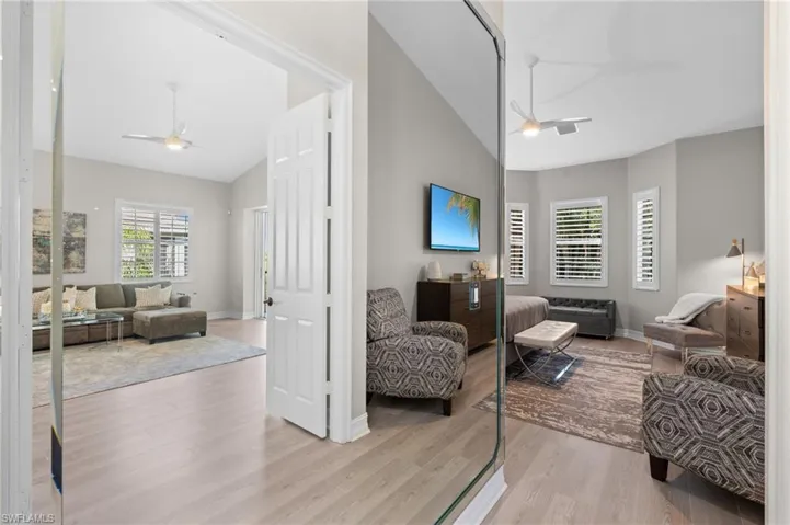 Living area featuring baseboards, a ceiling fan, wood finished floors, and vaulted ceiling