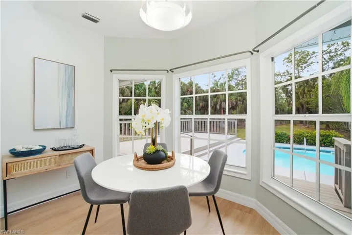 A charming bay-window dining nook that saturates the space with natural light and tranquil poolside views