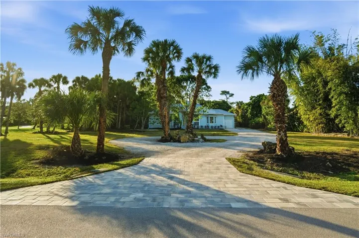 A gorgeous, manicured 2.5-acre estate entry framed by mature palms, setting the tone for privacy, beauty, and true Florida living.