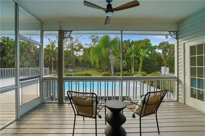A shaded screened oasis overlooking the pool and greenery, perfect for morning coffee or evening wine