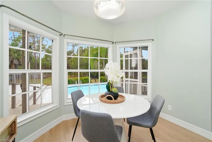 A charming bay-window dining nook that saturates the space with natural light and tranquil poolside views