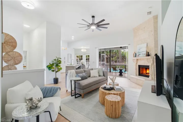 Bright, open living with a stunning custom travertine fireplace, seamless indoor-outdoor flow to the pool, and cozy spaces designed for relaxing, gathering, and true Florida living