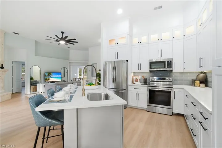 Stylish and functional, this redesigned kitchen features quartz counters, stainless appliances, white shaker cabinets, and an inviting breakfast bar for everyday dining.