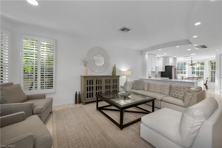 Living room with light tile patterned flooring and a chandelier