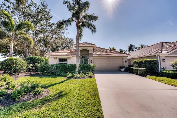 Mediterranean / spanish home with concrete driveway, stucco siding, a tiled roof, an attached garage, and a front yard