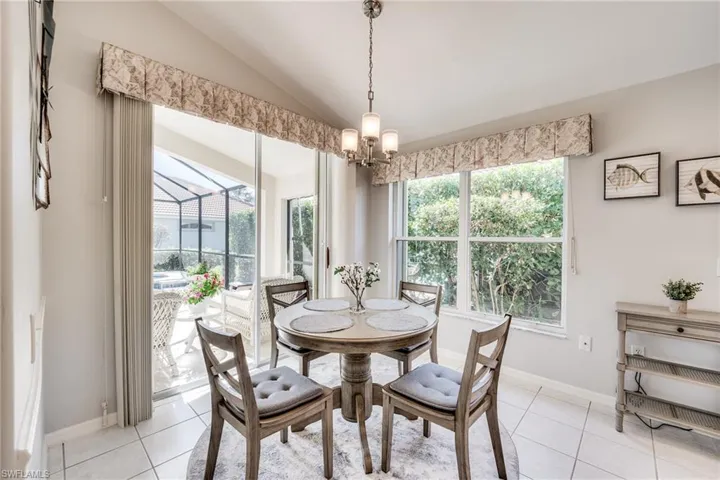 Dining area featuring vaulted ceiling, a wealth of natural light, and light tile patterned floors