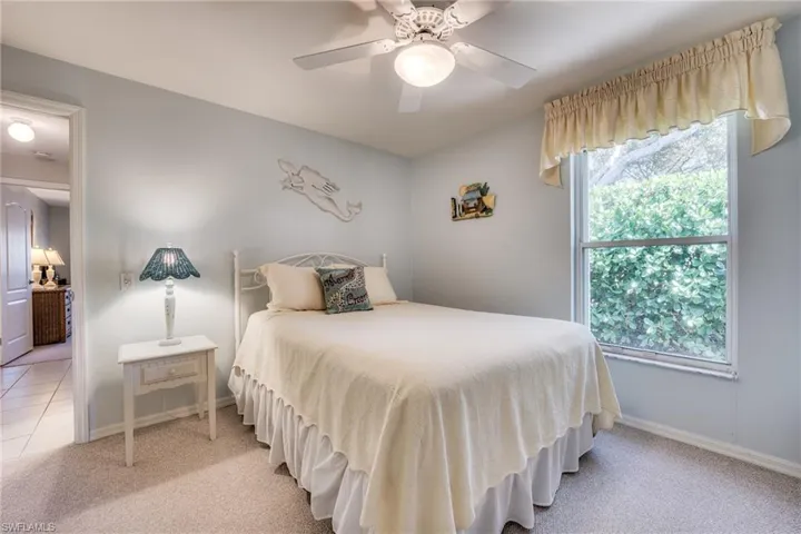 Bedroom featuring ceiling fan, light colored carpet, and multiple windows