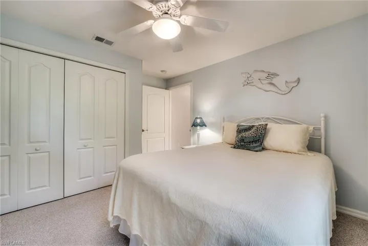 Carpeted bedroom featuring a closet and ceiling fan