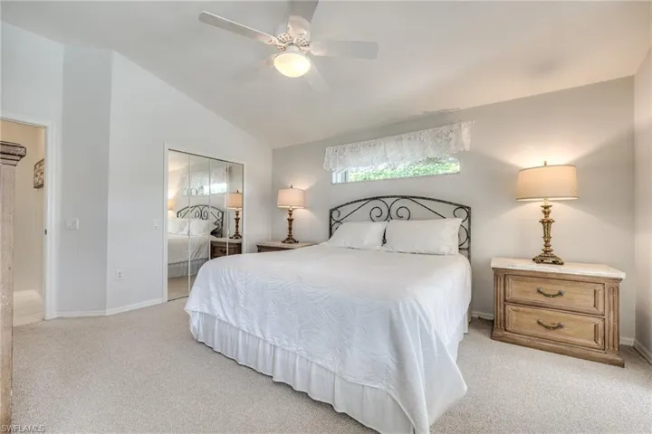 Bedroom featuring vaulted ceiling, light colored carpet, ceiling fan, and a closet