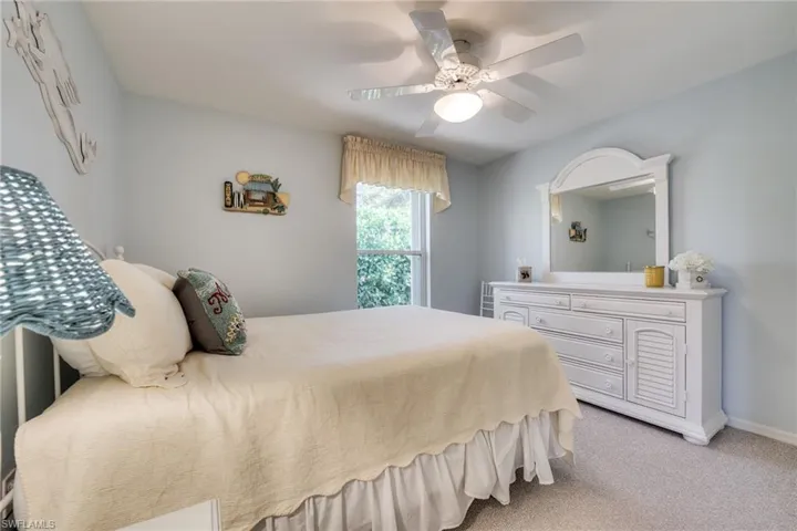 Bedroom with light carpet and ceiling fan