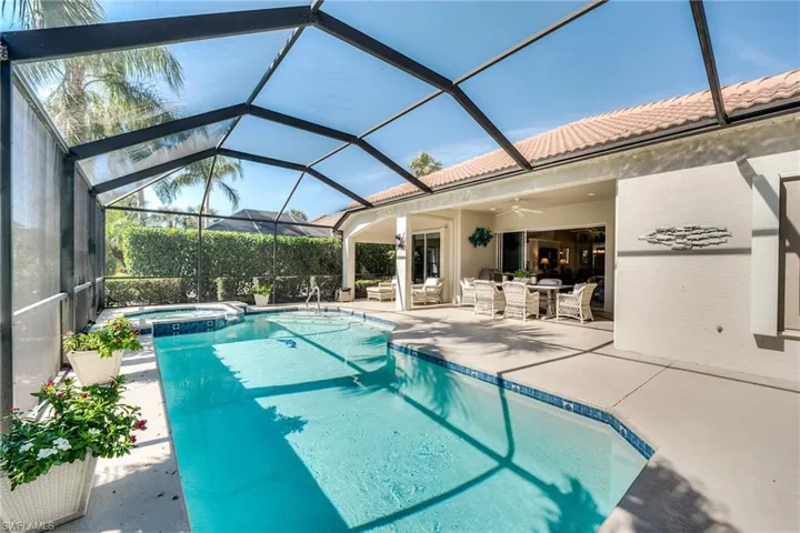 View of swimming pool with a lanai, a patio area, ceiling fan, and an in ground hot tub