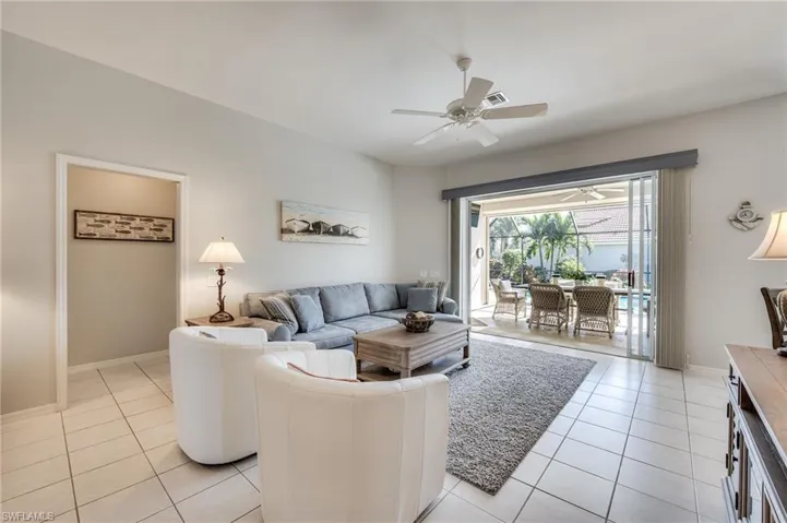 Living room featuring light tile patterned floors and ceiling fan