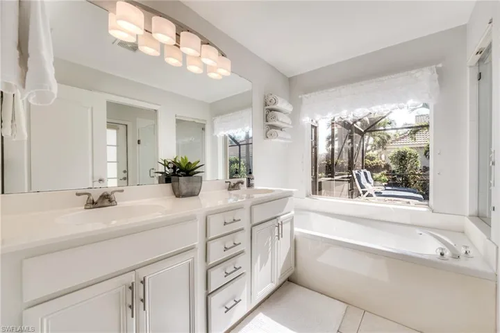 Bathroom with vanity, a bathtub, and tile patterned floors