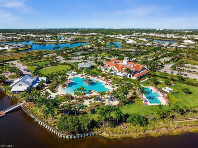 Aerial view of property and surrounding area featuring a large body of water and a pool