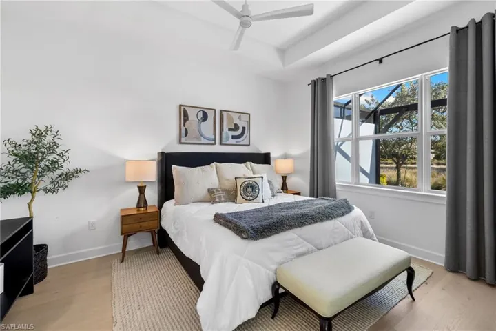 Premium wood floors elevate the spacious primary bedroom