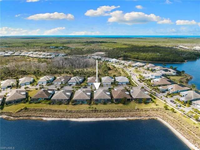 Aerial perspective of suburban area featuring a large body of water and a heavily wooded area