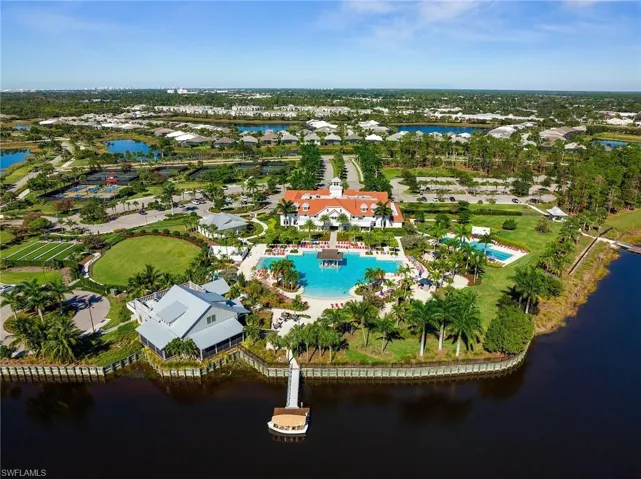 Aerial overview of property's location featuring a nearby body of water and a pool