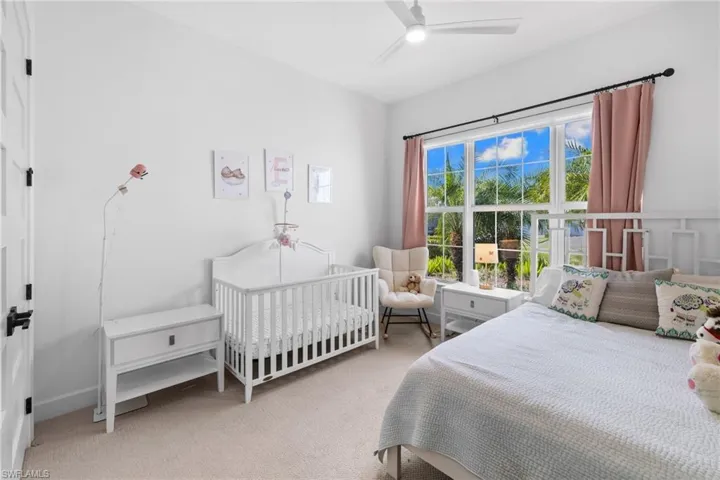 Bedroom featuring light colored carpet and a ceiling fan