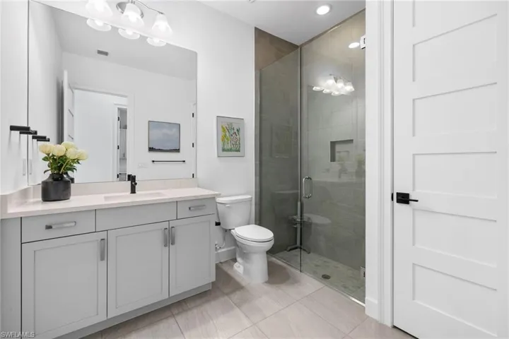 2nd full bathroom is spacious featuring shower with glass enclosure, neutral tile flooring and linen closet.