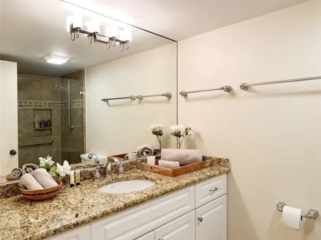 Full bath with vanity and tiled shower