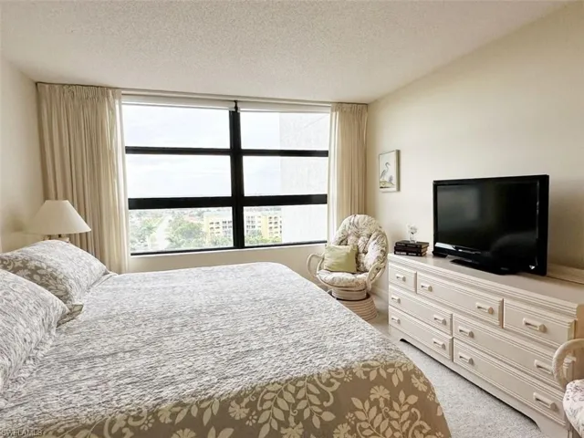 Bedroom featuring a textured ceiling and light carpet