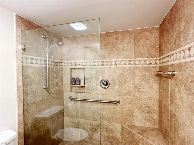 Bathroom featuring a tile shower and toilet